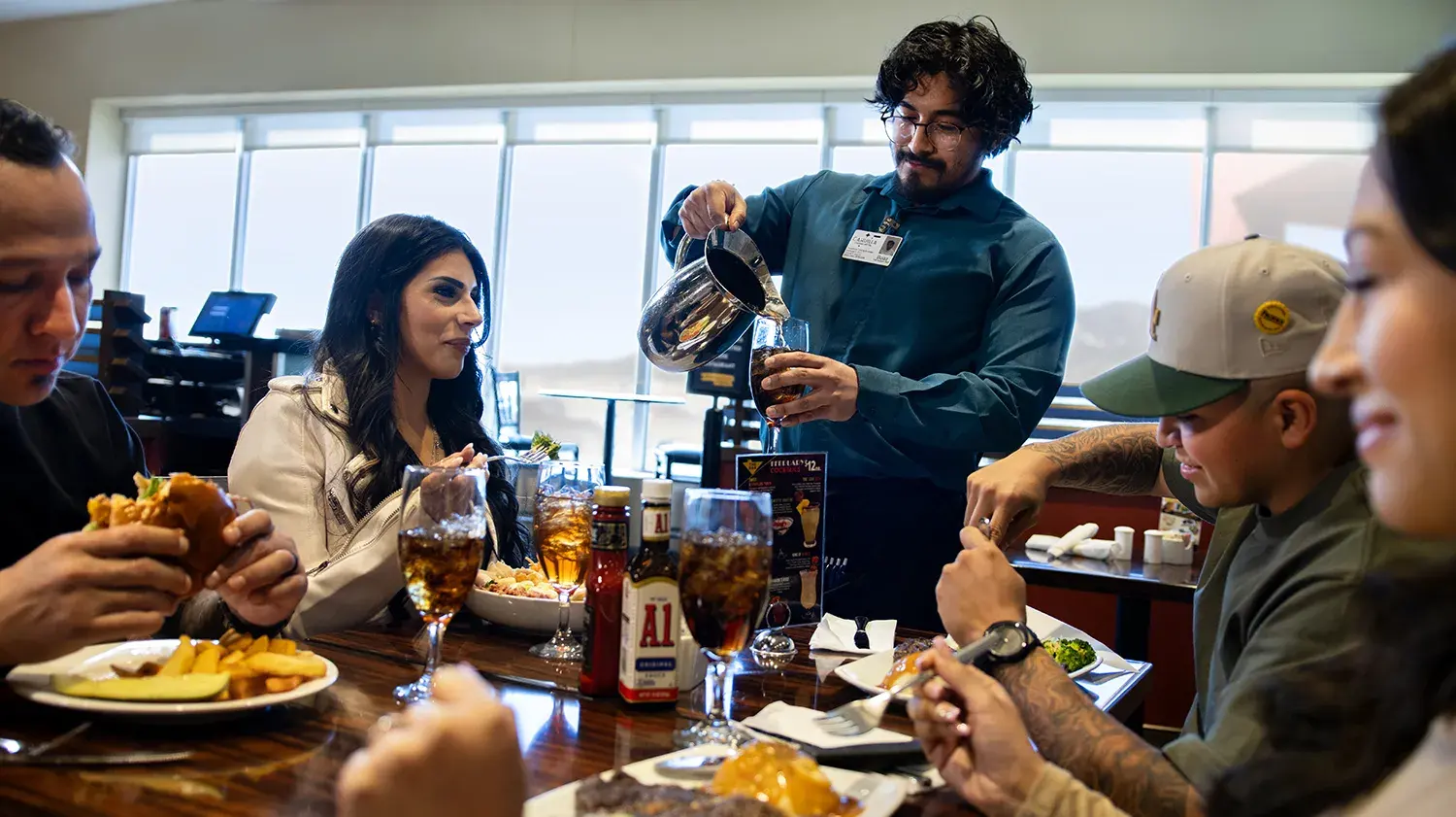 Server pouring a refill for a group dining at the Ribbonwood Grill